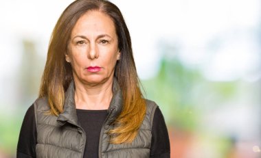 Kış yelek giyen güzel orta yaş kadın şüpheci ve sinir, sorun nedeniyle üzgün çatık. Negatif kişi.