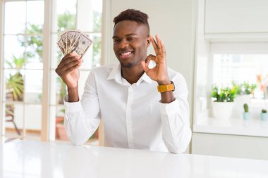 Afrika kökenli Amerikalı adam 50 dolar paralar parmak, mükemmel sembolü ile ok işareti yapıyor holding