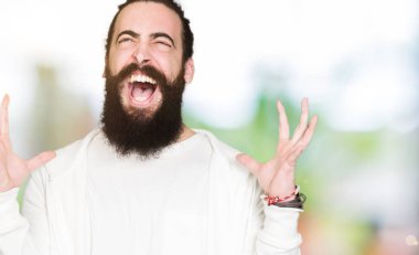 Uzun saç ve sakal kızgın ve silah ile başarı için deli kutluyor sportif sweatshirt giyen genç adamla kaldırdı ve heyecanlı çığlık gözler kapalı. Kazanan kavramı