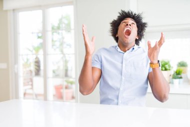 Afro-Amerikan iş adamı deli ve deli bağırarak ve agresif ifade ve silah kaldırdı ile bağırıyor. Hayal kırıklığı kavramı.