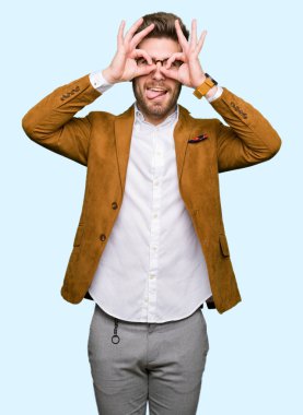 Dilini, parmaklarının arasından baktığını yapışmasını dürbün gibi ok jest yapıyor gözlüklü genç yakışıklı iş adamı. Deli ifade.