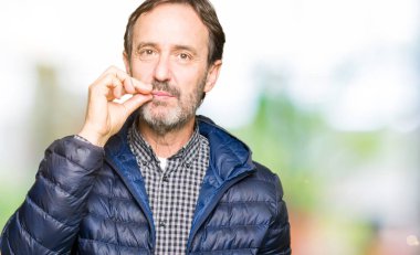 Olarak ZIP parmak ile orta yaş yakışıklı adam kış ceket ağız ve dudaklar kapatın. Gizli ve sessiz, tabu söz