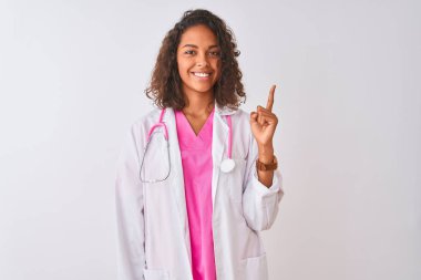 Genç Brezilyalı doktor kadın stetoskop giyen izole beyaz arka plan üzerinde başarılı bir fikir ile parmak işaret ayakta. Çıktı ve mutlu. Bir numara.