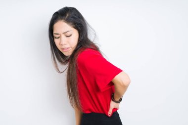İzole arka plan üzerinde kırmızı t-shirt giyen güzel esmer kadın sırt ağrısı acı, el ile geri dokunmadan, kas ağrısı