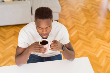 Afrika kökenli Amerikalı adam kendinden emin bir kahve içme evde gülümseyen