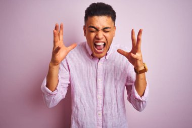 Genç Brezilyalı adam izole pembe arka plan üzerinde duran kollarını kaldırdı ve kapalı gözleri heyecan çığlık ile başarı için deli ve deli kutluyor. Kazanan kavramı