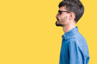 Genç yakışıklı adam giyen güneş gözlüğü izole arka tarafına, seyir üzerinde dinlenmek doğal yüz emin gülümseme ile pozuyla profili.