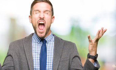 Yakışıklı iş adamı giyen takım elbise ve kızgın kutluyor kravat ve crazy arms ile başarı için kaldırdı ve heyecanlı çığlık gözler kapalı. Kazanan kavramı