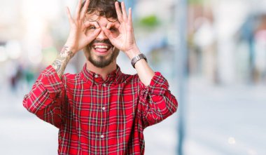 Dilini, parmaklarının arasından baktığını yapışmasını dürbün gibi ok jest yapıyor izole arka plan üzerinde gözlük takan yakışıklı delikanlı. Deli ifade.