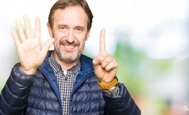 Kış ceket gösterme ve parmakları ile işaret giyen orta yaş yakışıklı adam kendinden emin ve mutlu gülümseyerek süre 6 numara.