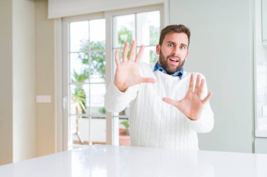 Rahat kazak giyen yakışıklı adam korku ve korku dan dehşete elleriyle jest durdurmak, şok içinde bağırarak. Panik kavramı.