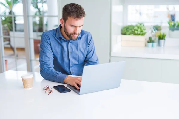 Knappe business man werken via computer laptop en glimlachen — Stockfoto