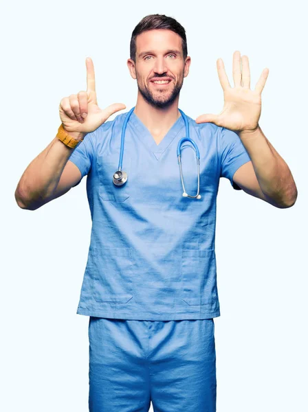 英俊的医生穿医疗制服在孤立的背景显示和手指指向七 同时微笑着自信和快乐 — 图库照片
