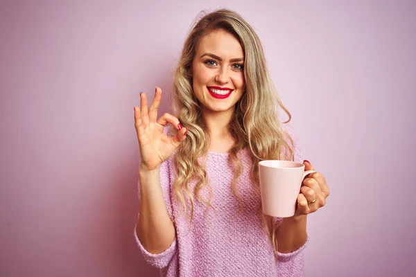 Młoda Piękna Kobieta Sobie Sweter Picia Filiżankę Kawy Nad Różowym — Zdjęcie stockowe