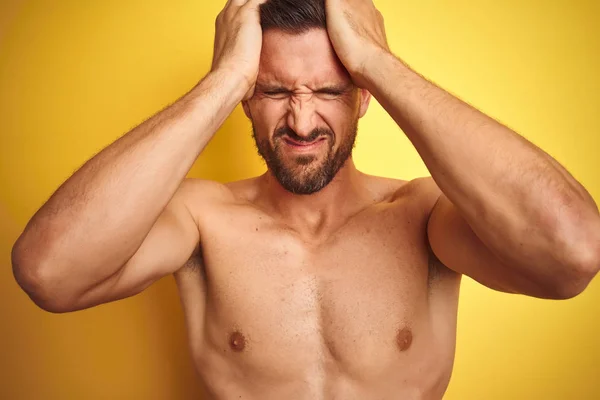 性感的年轻无衬衫男子显示裸体健身胸部在黄色孤立的背景遭受头痛绝望和压力 因为疼痛和偏头痛 手放在头上 — 图库照片