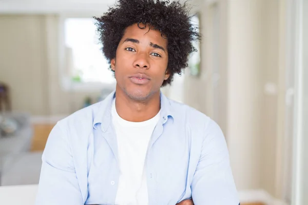 African American man at home Relaxed with serious expression on face. Simple and natural with crossed arms