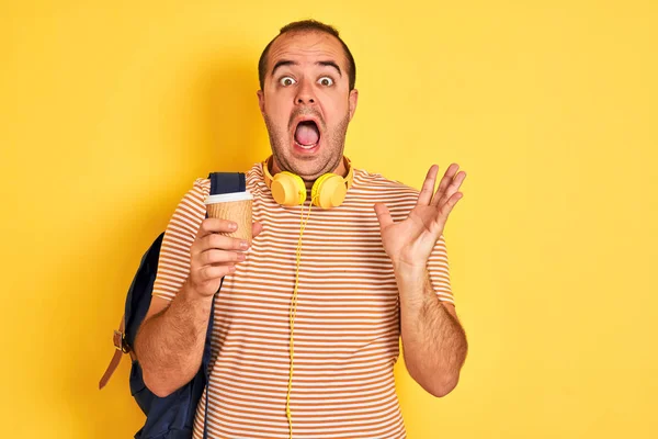 Estudiante Con Auriculares Mochila Bebiendo Café Sobre Fondo Amarillo Aislado —  Fotos de Stock