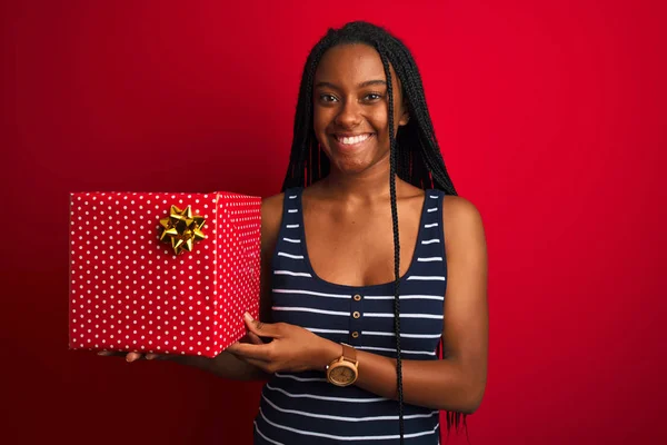 Junge Afrikanisch Amerikanische Frau Mit Geburtstagsgeschenk Vor Isoliertem Rotem Hintergrund — Stockfoto