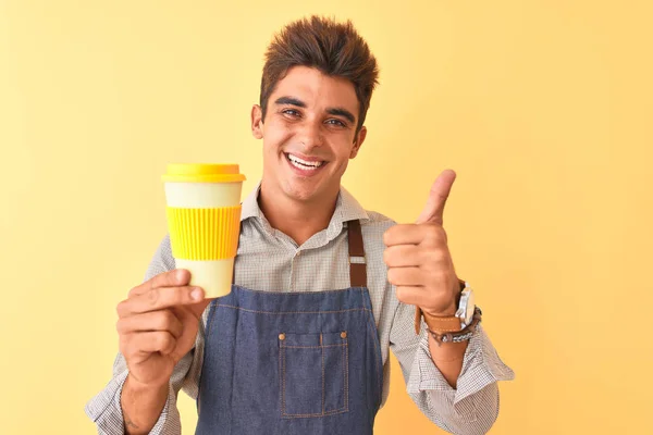 Joven Barista Guapo Con Delantal Sosteniendo Café Sobre Fondo Amarillo — Foto de Stock