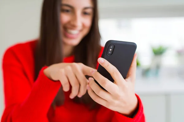 Jonge vrouw met behulp van smartphone, glimlachend gelukkig sms'en en typen — Stockfoto