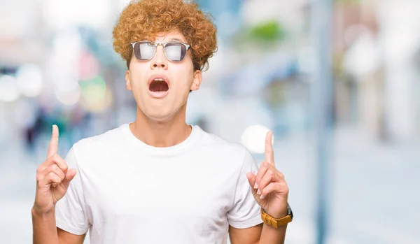 Ung Vacker Man Med Afro Hår Bär Solglasögon Förvånad Och — Stockfoto