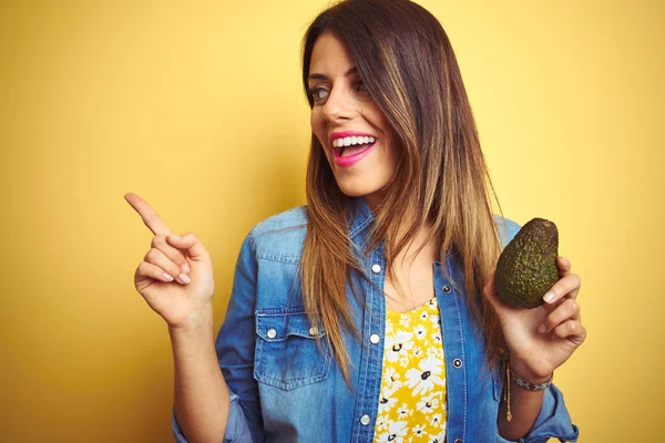 Joven Hermosa Mujer Comiendo Aguacate Saludable Sobre Fondo Amarillo Muy —  Fotos de Stock