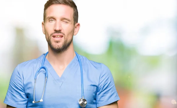 Bonito Médico Homem Vestindo Uniforme Médico Sobre Fundo Isolado Piscando — Fotografia de Stock