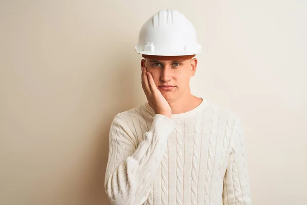 英俊的建筑师男子戴着安全帽站在孤立的白色背景思考看起来疲惫和无聊的抑郁症问题交叉手臂 — 图库照片