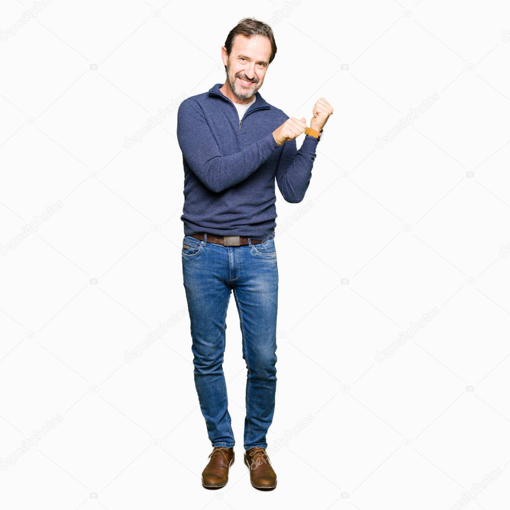 Middle age handsome man wearing a sweater Pointing to the back behind with hand and thumbs up, smiling confident