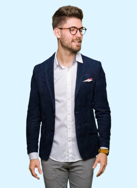 Uzak tarafına yüzünde, doğal ifade gülümseme ile seyir gözlüklü genç yakışıklı iş adamı. Kendine güvenen gülüyor.