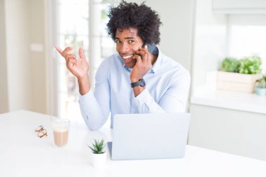 Afro-Amerikan iş adamı telefonda konuşurken çok mutlu yan el ve parmak ile işaret