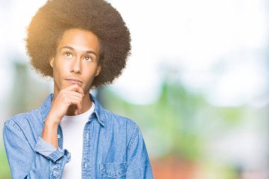 Çene düşünme hakkında soru, dalgın ifade üzerine el ile afro saçlı genç Afro-Amerikan adam. Düşünceli yüzüyle gülümsüyor. Şüphe kavramı.