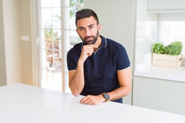 Yakışıklı İspanyol adam evde elleri çenesi ile soru, dalgın ifade düşünme. Düşünceli bir yüzle gülümsüyor. Şüphe kavramı.