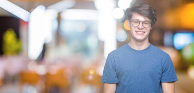 Yüzünde mutlu ve güzel bir gülümseme ile izole arka plan üzerinde gözlük takan yakışıklı delikanlı. Şanslı kişi.