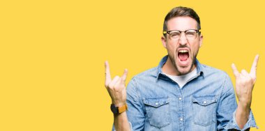 Yakışıklı adam deli ifade rock simge elle yapıyor ile bağırarak gözlük takıyorum. Müzik yıldızı. Ağır kavramı.