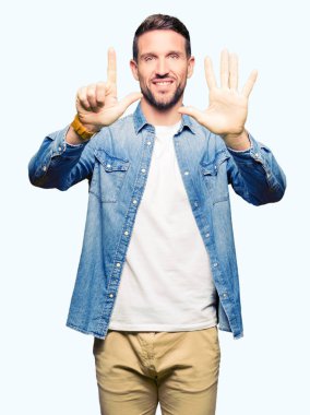 Sakal üzerinde gösterilen ve parmakları ile işaret denim ceket ve mavi gözlü yakışıklı adamla kendinden emin ve mutlu gülümseyerek süre yedi numara.