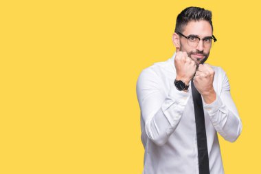 Genç yakışıklı iş adam gözlük izole arka plan üzerinde yumruk savunma hareketi, kızgın ve üzgün yüz, sorunu korkuyor ile savaşmaya hazır