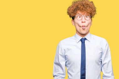Afro giyen ile genç yakışıklı iş adamı dudaklı, çılgın ve komik bir jest yapma balık yüz gözlük. Komik ifade.