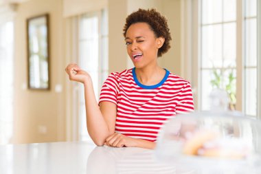 Evde Genç güzel Afrikalı Amerikalı kadın seksi ifade, neşeli ve mutlu yüz ile kamera bakarak göz kırpıyor.