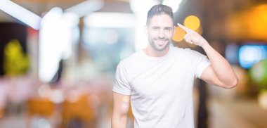 Yakışıklı adam gece açık havada arka plan üzerinde beyaz t-shirt giyen tek parmak, harika bir fikir ya da düşünce, iyi bellek ile baş işaret