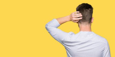 Genç yakışıklı adam Geriye başında el ile şüphe düşünme