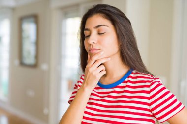 Genç güzel kadın düşünme ve çene üzerinde bir el ile merak