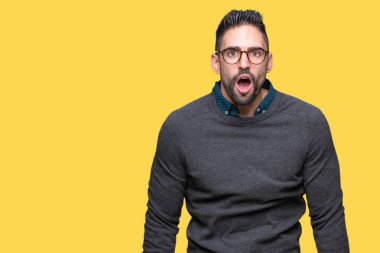 Korkuyor ve şok sürpriz ifade, korku ve heyecan yüz ile izole arka plan üzerinde gözlük takan genç yakışıklı adam.