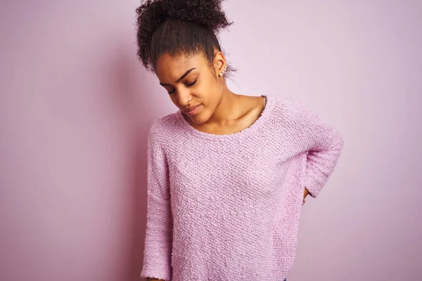 Young african american woman wearing winter sweater standing over isolated pink background Suffering of backache, touching back with hand, muscular pain