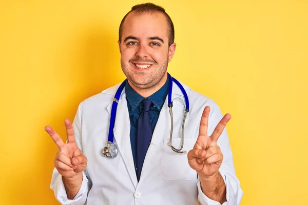 Joven Doctor Con Abrigo Estetoscopio Parado Sobre Fondo Amarillo Aislado — Foto de Stock