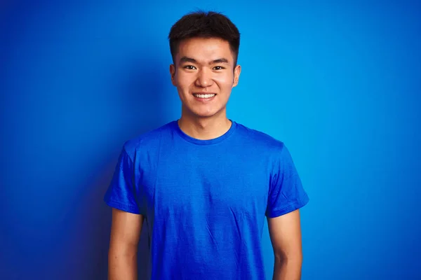 青い背景に立つTシャツを着たアジアの若い中国人男性が 幸せでクールな笑顔を浮かべていた ラッキーな人 — ストック写真