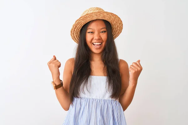 年轻的中国妇女穿着条纹礼服和帽子站在孤立的白色背景非常高兴和兴奋做胜利者手势与手臂抬起 微笑和尖叫的成功 庆典概念 — 图库照片