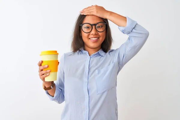 Young chinese woman wearing glasses holding glass of coffee over isolated white background stressed with hand on head, shocked with shame and surprise face, angry and frustrated. Fear and upset for mistake.