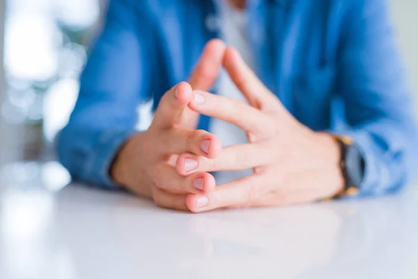 Primer plano de las manos del hombre con las palmas juntas sobre la mesa blanca — Foto de Stock