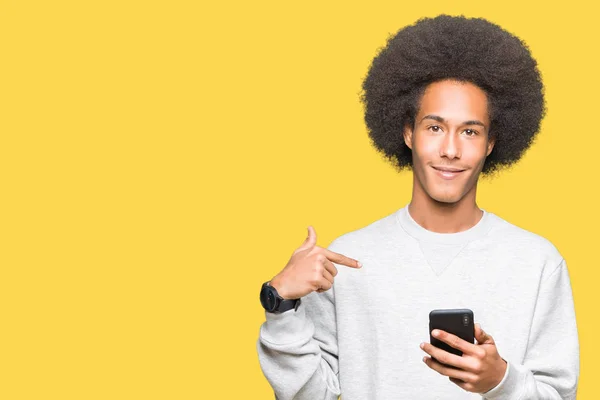 Americký Mladík Afro Vlasy Pomocí Smartphone Překvapením Tvář Ukazováčkem Sebe — Stock fotografie